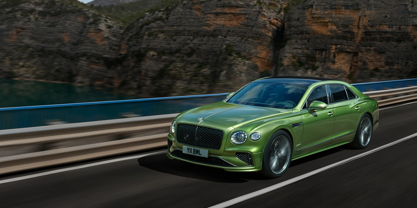 Bentley Istanbul Bentley New Flying Spur Speed v8 hybrid sedan driving dynamically on a mountain road in Tourmaline Green paint