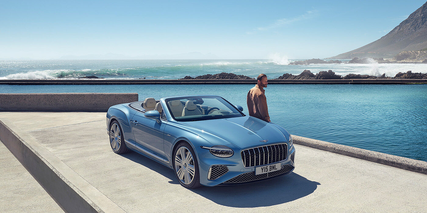 Bentley Istanbul New Bentley Continental GTC Azure convertible front view in Light Windsor blue paint with 22 inch ten spoke wheels parked by the sea in the sunshine