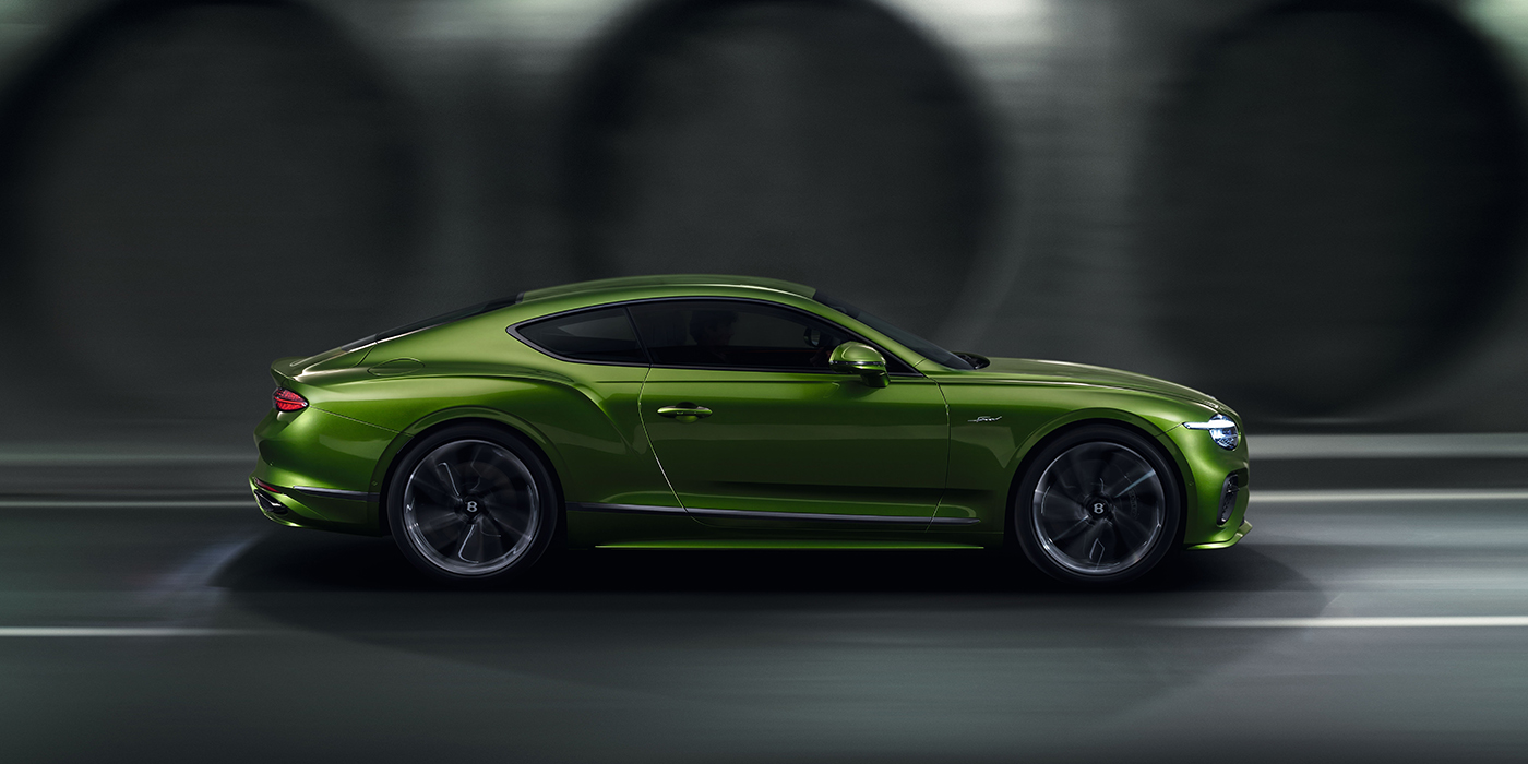 Bentley Istanbul Bentley Continental GT coupe in Tourmaline Green paint driving in profile on a dark road