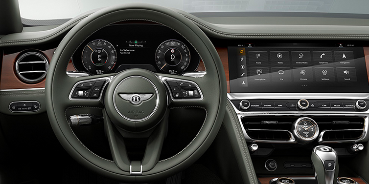 Bentley Istanbul New Bentley Flying Spur front cabin interior in Cumbrian green hide with Crown Cut walnut veneer showing steering wheel and driver controls